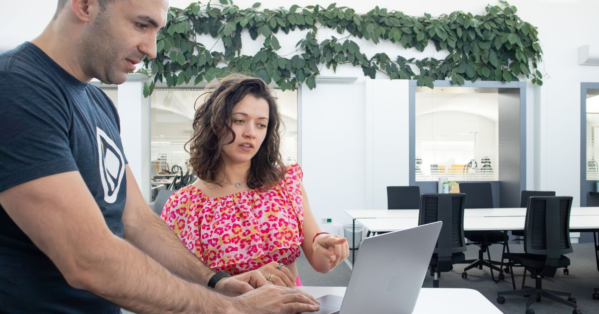 Zwei Personen besprechen eine Aufgabe am Laptop