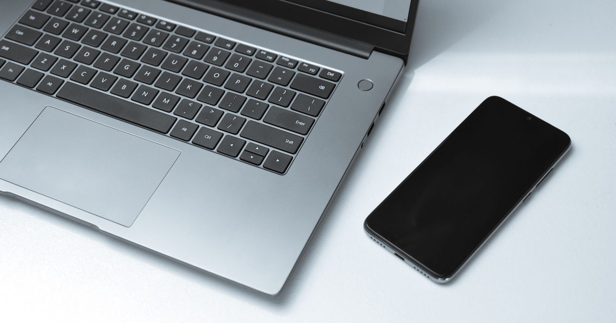 Laptop und Smartphone auf einer hellen Arbeitsfläche